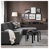 Modern living room with gray SÖRVALLEN sectional sofa, black nesting tables, patterned rug, and wall art.