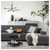 Modern living room with a gray SÖRVALLEN sofa, featuring a coffee table, decor, and pendant lights.