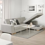 Modern sofa with extendable chaise, minimalist style, pillows, coffee table, rug, wall art