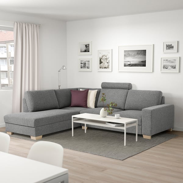 Modern living room: gray SÖRVALLEN l-shaped sofa, white coffee table, art wall, large window with light curtains.