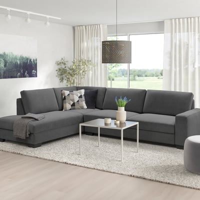 Modern living room with gray SÖRVALLEN sofa, white coffee table, blue flowers, pendant lamp, and large windows.