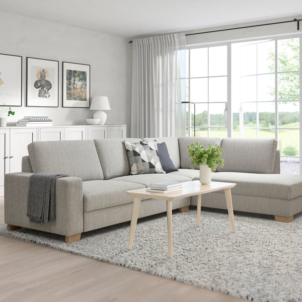 Modern living room with corner sofa, light gray fabric, chic minimalist design, large windows, cozy ambiance.