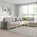 Modern living room with corner sofa, light gray fabric, chic minimalist design, large windows, cozy ambiance.