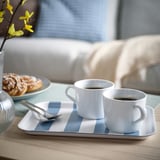 Tray SOLDATFISK, white/blue striped, rectangular, holds two coffee cups and a plate with pastries. Fits well on a table, light wooden surface.