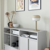 White bookshelf with lamp, books, and decor.