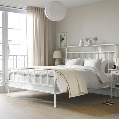 Modern bedroom with white STJÄRNÖ bed, large window, pendant lamp, and striped rug.