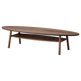 The STOCKHOLM coffee table in walnut wood. Its oval top and tapered legs give it a sleek, modern look. A lower shelf offers additional storage.
