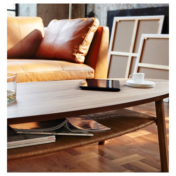 Modern coffee table with smartphone, cup in living room.