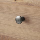 Close-up of wooden drawer handle with sturdy, dark finish and visible wood grain.