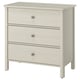 Option: A white, three-drawer chest. It has round knobs and sturdy legs for stability. Perfect for storage with a clean design.