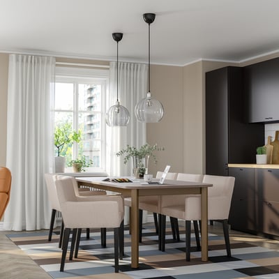 Modern dining set with STRANDTORP table, beige chairs, pendant lights, and large windows.