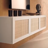 White cabinet with woven panel fronts, holding black cups.