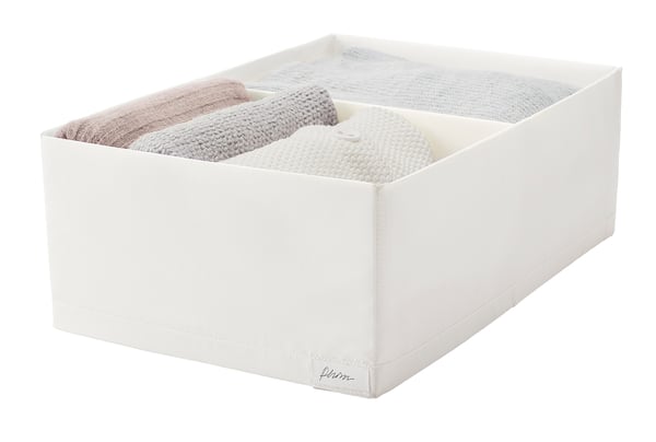 White STUK box with folded knitted items, clear lid, polyester. Alternatively: STUK box with knitted socks/gloves, clear lid, polyester.