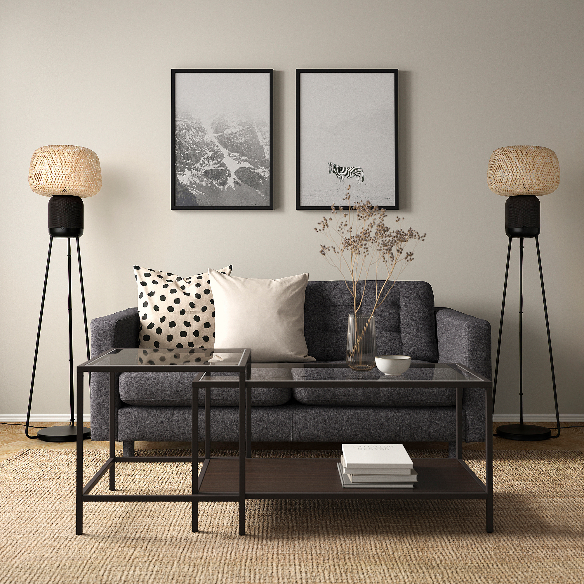 Modern living room with SYMFONISK wi-fi speaker floor lamp on both sides of grey couch. Framed art on wall, glass coffee table with books.