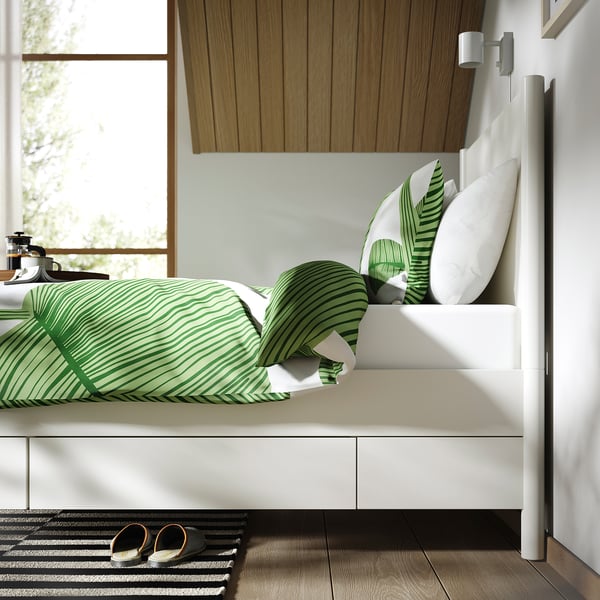 Bed frame with drawers, soft-close feature, and sturdy construction. Green patterned bedding and pillows.