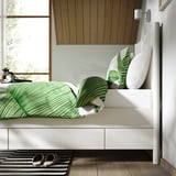 Bed frame with drawers, soft-close feature, and sturdy construction. Green patterned bedding and pillows.