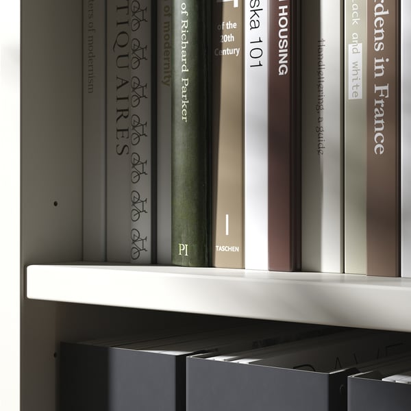 Books on white modern shelves, minimalist and organized.