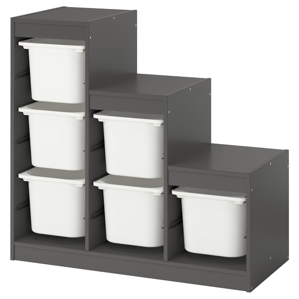 An ikea TROFAST storage unit in grey with white bins for kids. It categorical storage with interchangeable shelves and drawers.