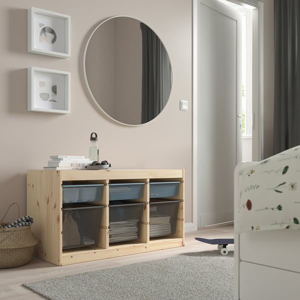 Wooden TROFAST storage unit with mesh boxes, minimalist design. Against a wall with mirror, framed pictures.