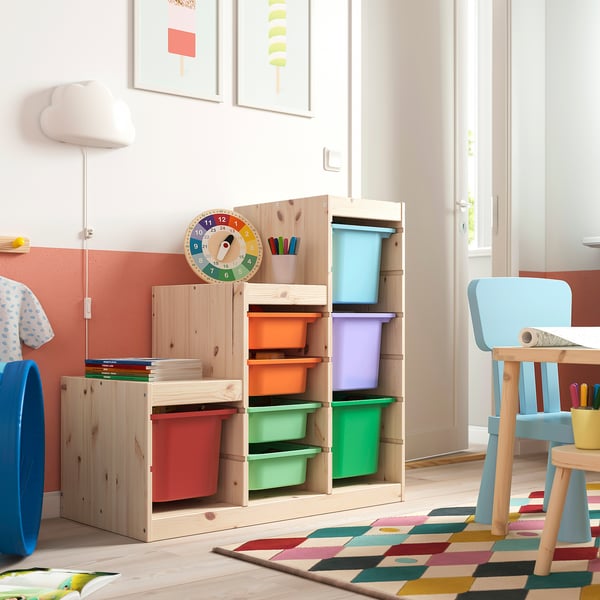 Kids playroom with TROFAST storage unit, colorful plastic bins, wooden frame. Bright, kid-friendly decor.