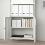 White cabinet with adjustable shelves, lockable doors, and adjustable feet, storing files and books.