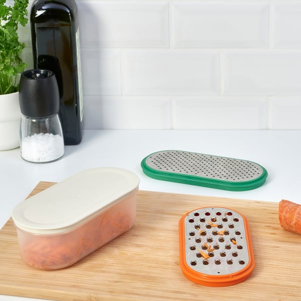 Two graters and a container with lid on kitchen counter.