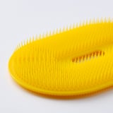 Yellow veggie brush with flexible bristles for gentle cleaning.