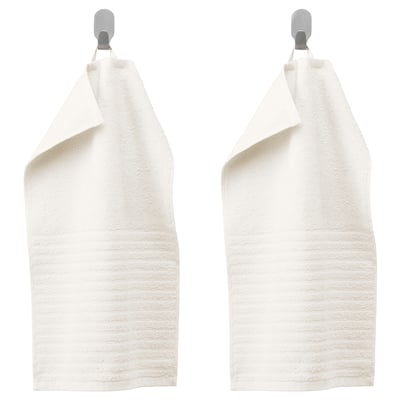 Two white VÅGSJÖN towels hang on silver hooks, texture visible.