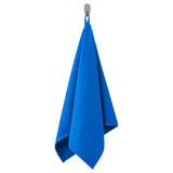 A blue VÅGSJÖN towel hangs on a hook, crafted from 100% cotton in a soft, rib-weave design.
