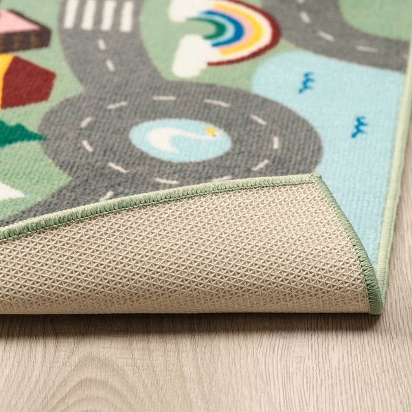 Childs play rug with city, rainbow, and vehicles. Non-slip back shown.