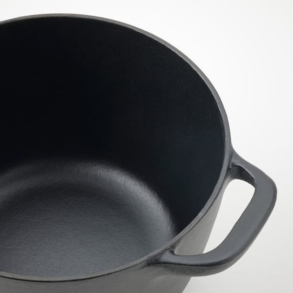 Black cast iron pan with two side handles and smooth interior finish.