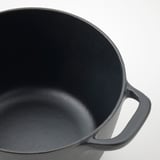 Black cast iron pan with two side handles and smooth interior finish.