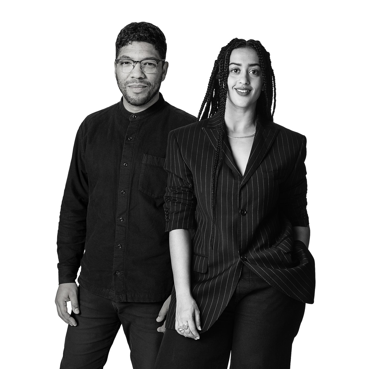 Black and white photo of the two designers posing together, dressed in formal attire.