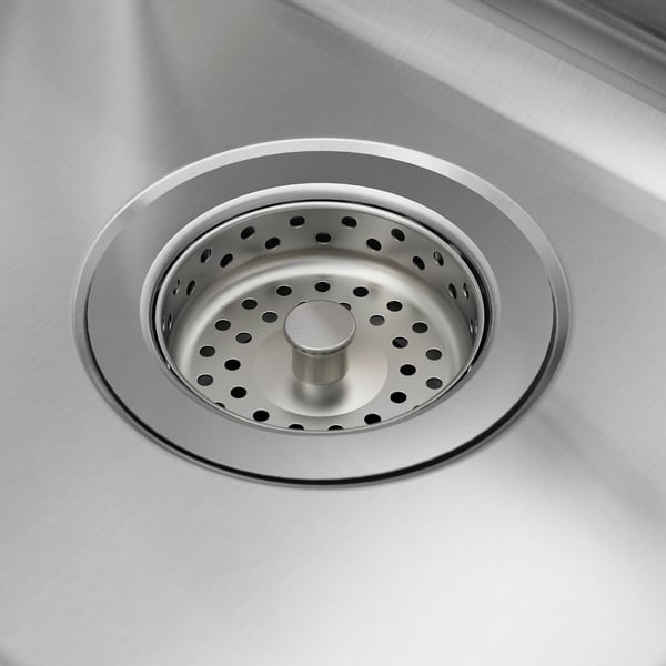 Stainless steel sink drain with strainer, clean and durable. Circular shape with multiple holes for efficient draining.