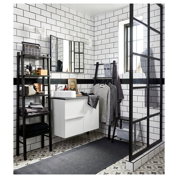 Modern bathroom with VILTO black towel rack, white sink, andsubway tiles.