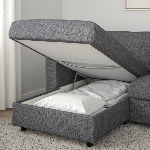 Grey fabric sofa bed in use, revealing thick mattress and metal frame.