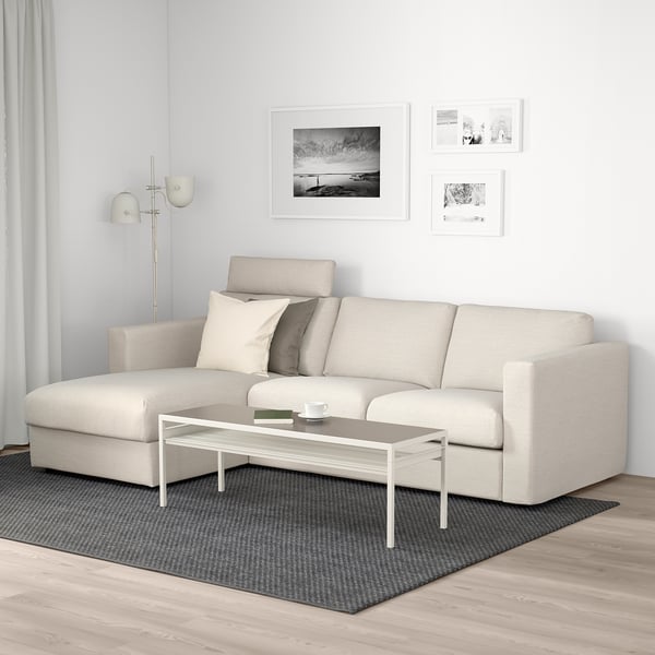Modern living room with VIMLE beige sofa, white coffee table, gray rug, and wall art.