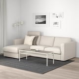 Modern living room with VIMLE beige sofa, white coffee table, gray rug, and wall art.
