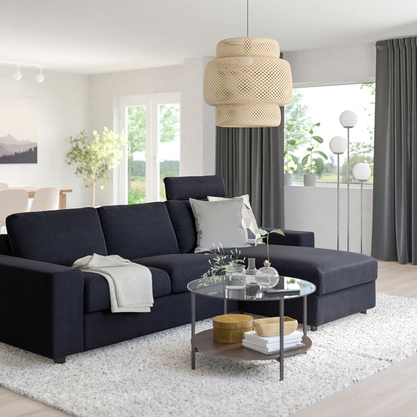 Modern living room with large grey VIMLE sofa, white rug, glass coffee table, and natural pendant lamp.