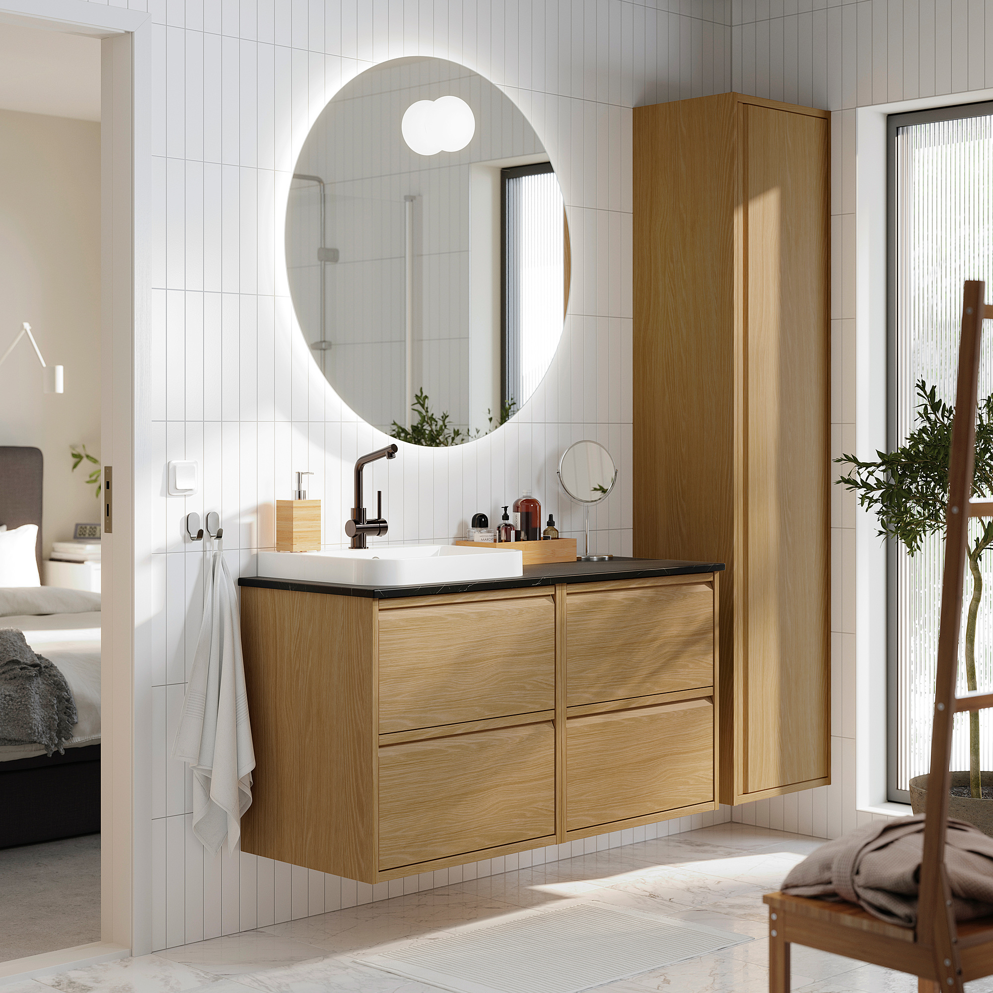 Salle de bains moderne avec meuble-lavabo en bois de couleur claire, miroir penché et articles de toilette.