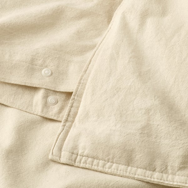 Gros plan de la housse de couette avec fermeture à boutons, coton naturel doux.