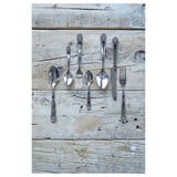 Set de couverts en acier inoxydable : cuillères, fourchettes, couteau, cuillère à café sur bois patiné.