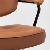 Détail de la chaise de bureau en cuir marron, mettant en valeur des coutures de haute qualité et une finition lisse.