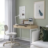 Bureau à domicile avec bureau ALEX, chaise, lampe et décor contre des murs verts.