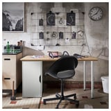 Configuration de bureau de style industriel avec plateau en bambou ANFALLARE, chaise noire, horloge murale et présentoir d’art.