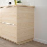 Armoires de cuisine en bois clair ASKERSUND, design élégant et moderne, plus hautes que les articles à proximité.
