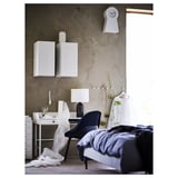 Chambre moderne à la décoration monochrome, dotée d’un bureau, d’armoires flottantes, d’un lit et d’une horloge.