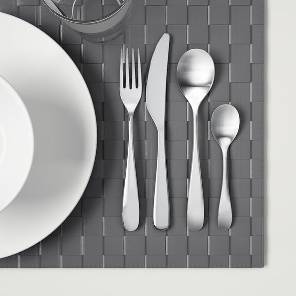 Set de couverts en acier inoxydable sur napperon gris.
