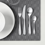 Set de couverts en acier inoxydable sur napperon gris.