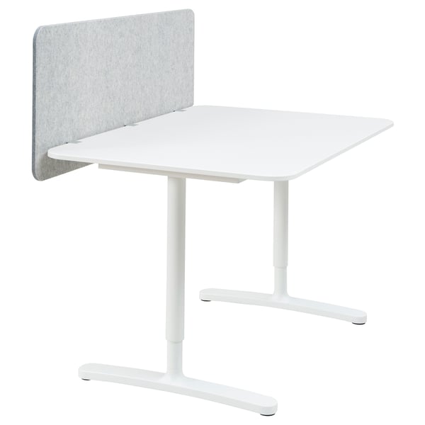 Un bureau BEKANT blanc avec une hauteur réglable, doté d’un écran insonorisant gris sur le côté gauche.